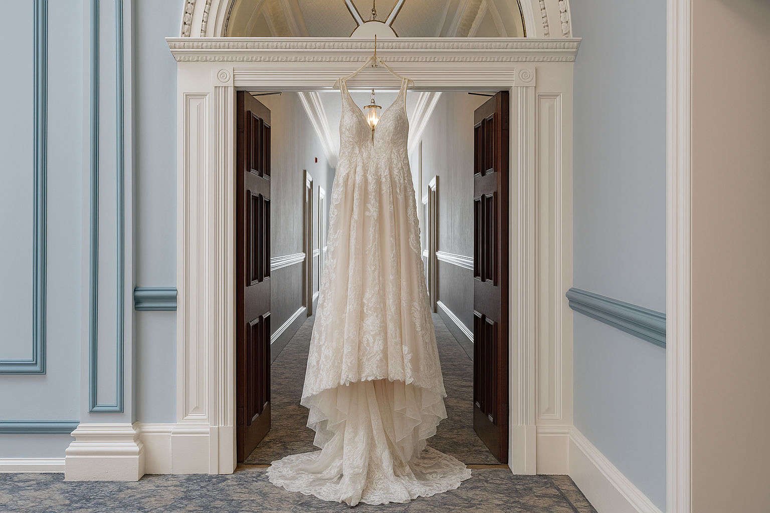 Wedding dress hanging in a grand hallway at Shrigley Hall, Manchester.
